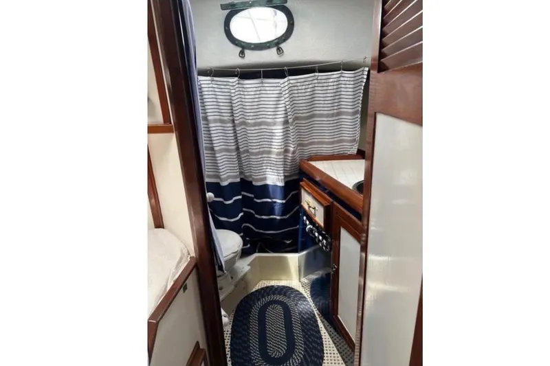 Slide: The Image of The image shows a boat bathroom with a shower curtain, toilet, and sink. - 7