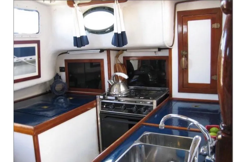Slide: The Image of The galley of a 1978 CSY 37 with a stove, sink, and blue countertop area. - 5