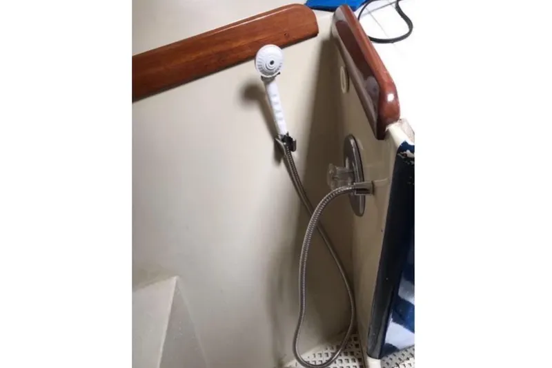 Slide: The Image of A showerhead with a hose is mounted on the wall of a boat bathroom. - 10