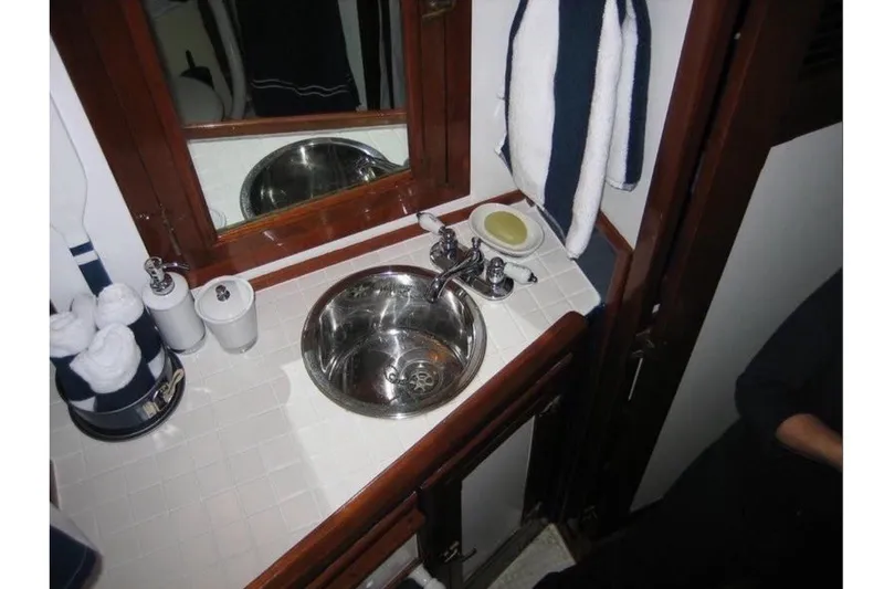 Slide: The Image of The image shows a boat bathroom with a round stainless steel sink, mirror, and towels. - 8