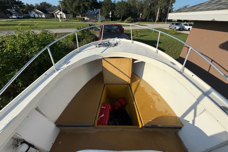 Slide: The Image of 1977 Mako 235 boat interior with open storage compartment and life jackets. - 34