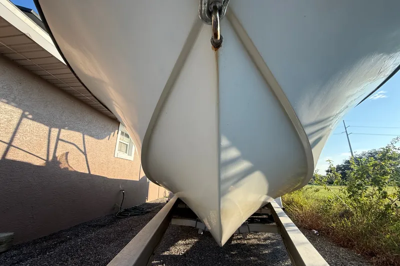 Slide: The Image of 1977 Mako 235 boat hull on trailer, side view near building. - 10