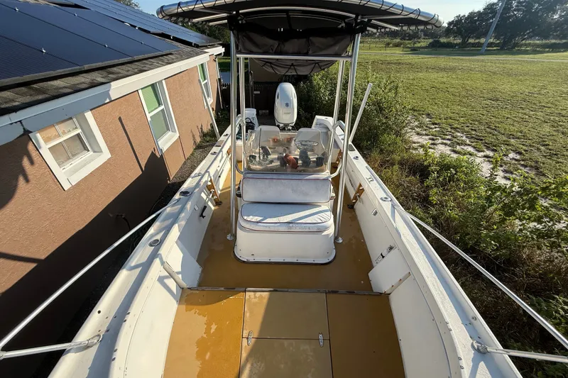Slide: The Image of 1977 Mako 235 boat with canopy, parked beside a house with solar panels. - 14