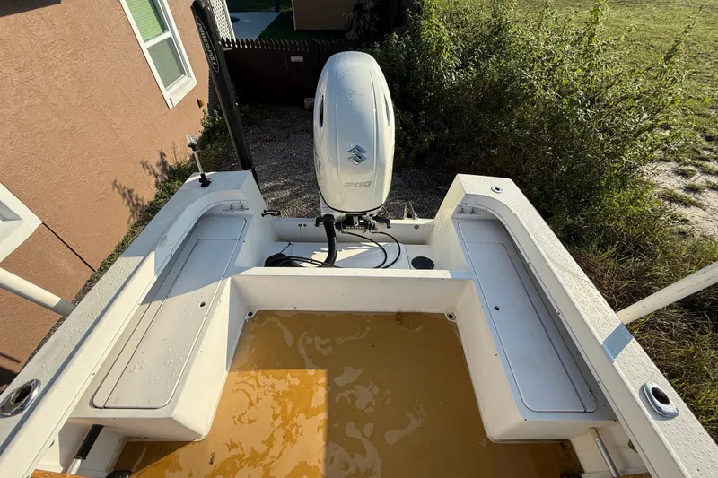 Slide: The Image of 1977 Mako 235 boat with Suzuki outboard motor, parked outdoors. - 20