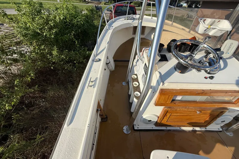 Slide: The Image of 1977 Mako 235 boat interior with steering wheel and control panel. - 28