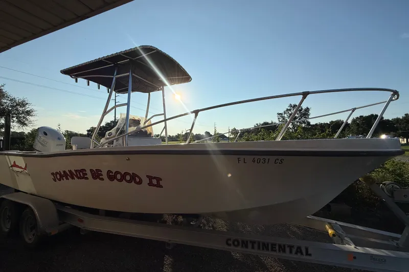 Slide: The Image of Un bateau Mako 235 de 1977 sur une remorque, avec un pare-soleil et un moteur hors-bord. - 7