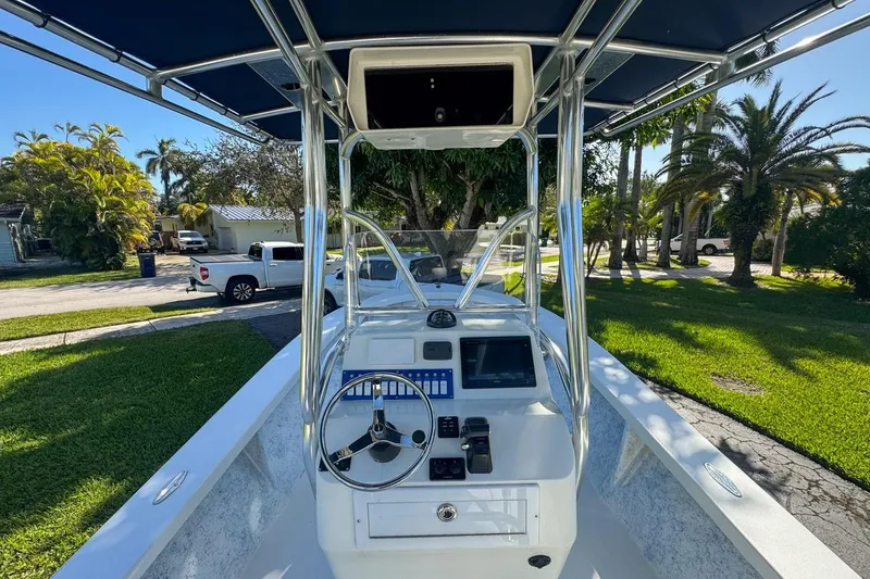 Slide: The Image of 1972 Cuda Craft Open Fisherman boat with steering console, parked in a sunny residential area. - 19