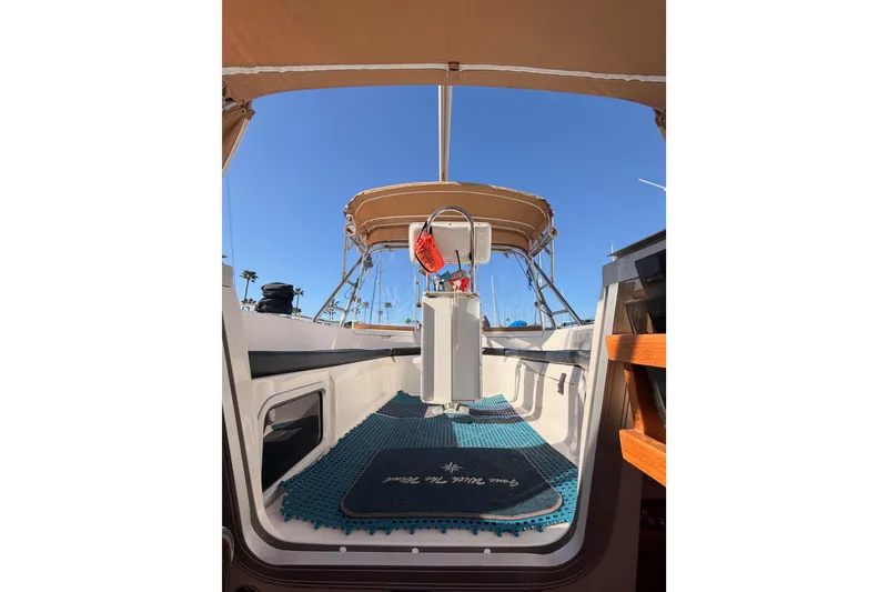Slide: The Image of Interior view of 2005 Hunter Passage 456 sailboat cockpit with blue mat and canopy. - 83