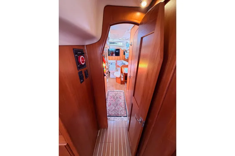 Slide: The Image of Interior view of 2005 Hunter Passage 456 yacht, featuring wooden paneling and cozy cabin space. - 80