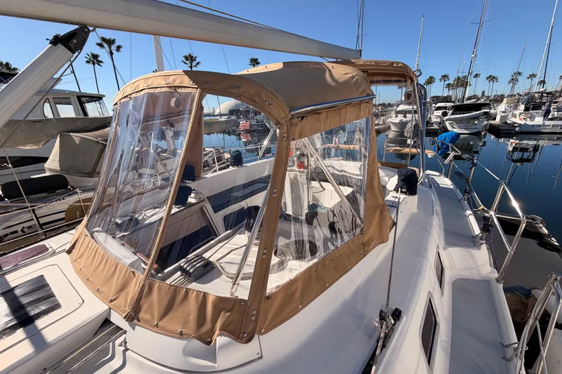 Slide: The Image of 2005 Hunter Passage 456 sailboat with tan canopy docked in marina. - 23