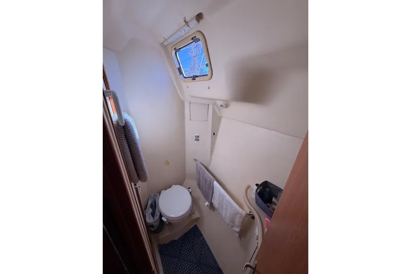 Slide: The Image of Compact bathroom in 2005 Hunter Passage 456 yacht, featuring a toilet and towel rack. - 79