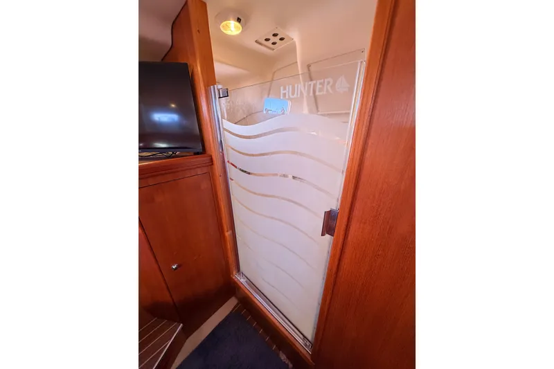 Slide: The Image of Interior of 2005 Hunter Passage 456 yacht with wooden cabinetry and frosted glass door. - 76