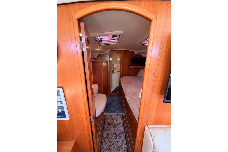 Slide: The Image of Interior view of 2005 Hunter Passage 456 yacht cabin with wood finish and cozy furnishings. - 54
