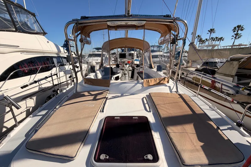 Slide: The Image of 2005 Hunter Passage 456 sailboat docked at marina, featuring spacious deck and seating area. - 10