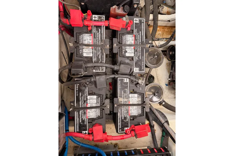 Slide: The Image of Battery compartment of a 2005 Sea Ray 300 Sundancer boat, showing four connected batteries. - 47