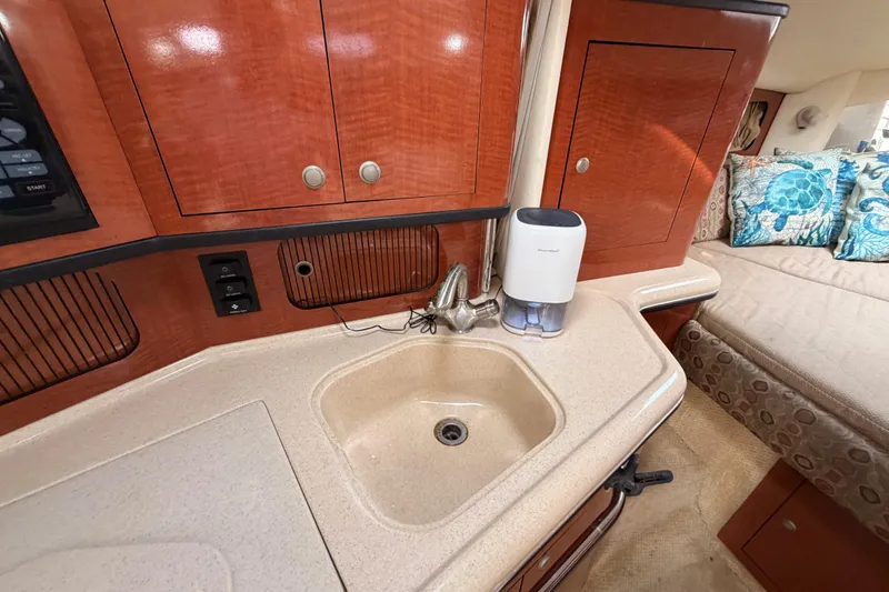Slide: The Image of 2005 Sea Ray 300 Sundancer cabin interior with sink and wooden cabinetry. - 32