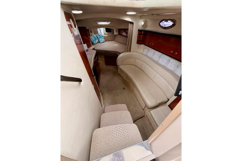 Slide: The Image of Interior of 2005 Sea Ray 300 Sundancer boat with beige seating and cozy cabin. - 24
