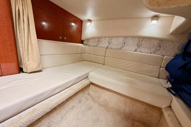 Slide: The Image of Interior cabin of 2005 Sea Ray 300 Sundancer with beige seating and wood accents. - 40