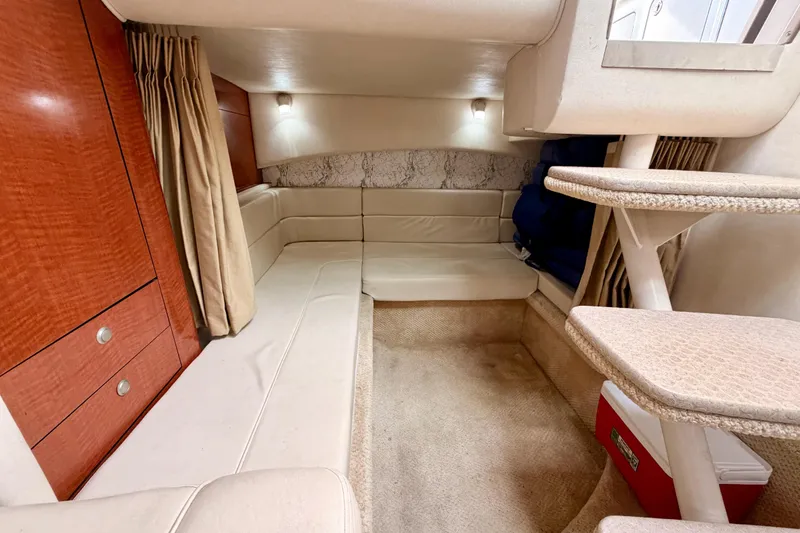 Slide: The Image of Interior cabin of 2005 Sea Ray 300 Sundancer with beige seating and wooden cabinetry. - 39