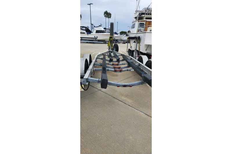 Slide: The Image of Boat trailer for 2004 Grady White 232 Gulfstream, parked on concrete, with boats in background. - 15
