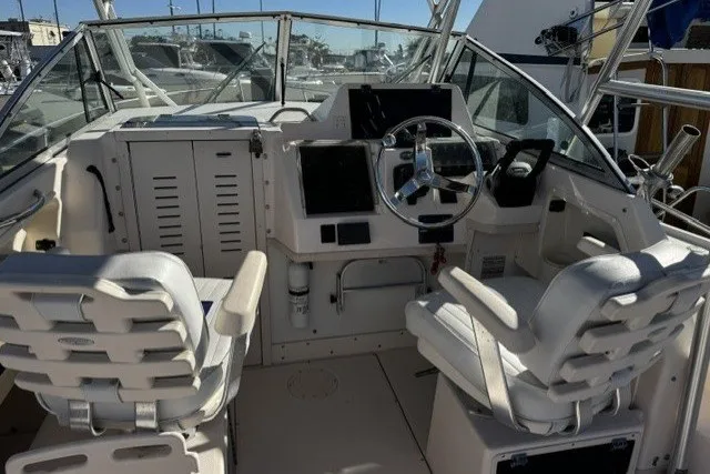 Slide: The Image of 2004 Grady-White Gulfstream 232 boat cockpit with dual white captain chairs and steering console. - 19