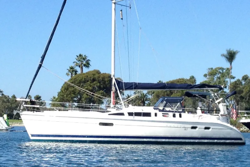 The Image of 2002 Hunter 410 sailboat on calm water with trees in the background. - 0