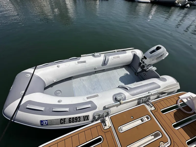 Slide: The Image of A gray inflatable boat with an outboard motor is docked at a wooden pier. - 42