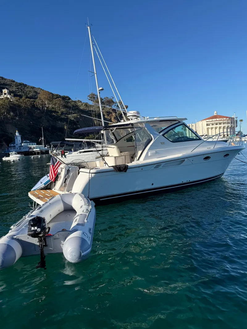 The Image of A 2007 Tiara Yachts 3000 Open is anchored in clear water, with a dinghy in tow. - 0
