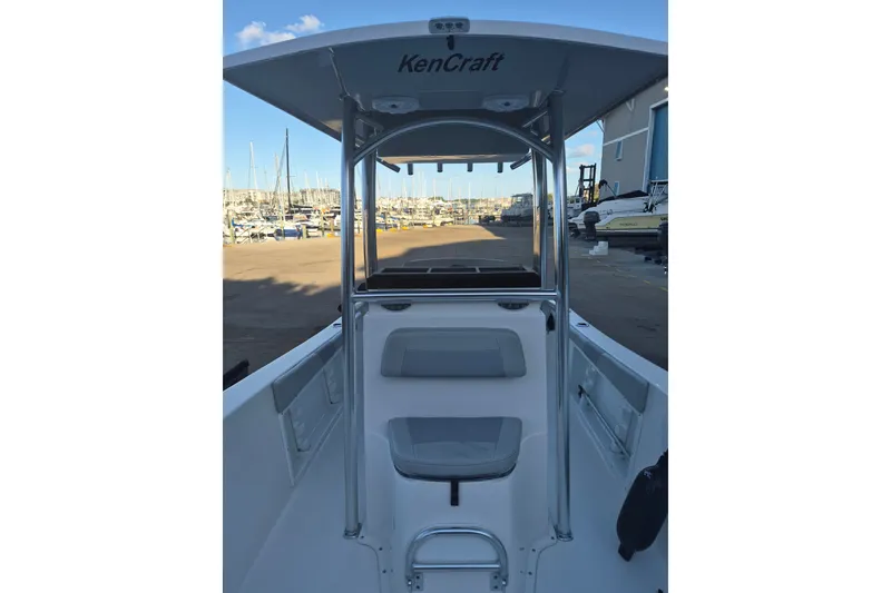 Slide: The Image of 2024 KenCraft 215 Center Console boat at marina, showcasing helm and seating area. - 14