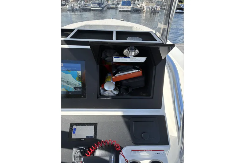 Slide: The Image of 2024 KenCraft 215 Center Console dashboard with navigation equipment and storage compartment. - 26