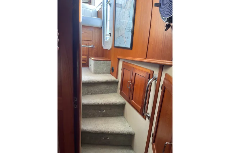 Slide: The Image of Interior stairs of 2003 American Tug 34 with wooden cabinetry and carpeted steps. - 15