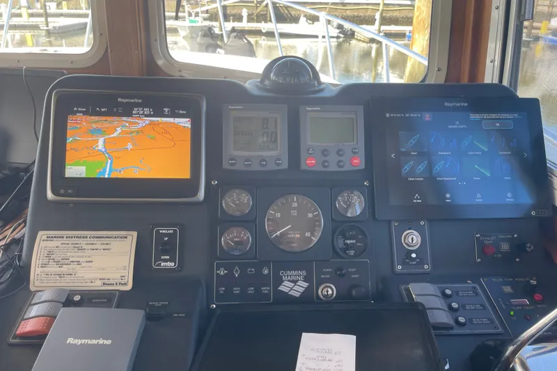 Slide: The Image of American Tug 34 (2003) helm with navigation and control panels, featuring Raymarine displays. - 10