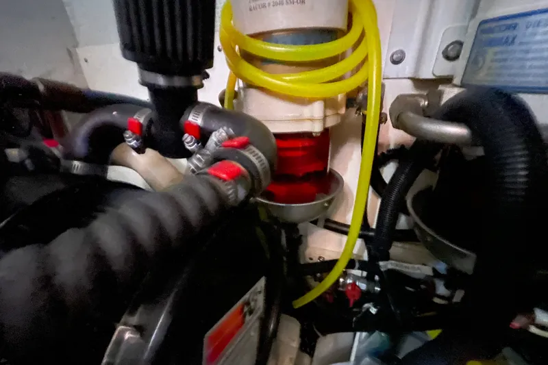 Slide: The Image of Engine compartment of a 2003 American Tug 34 with hoses and filters visible. - 24