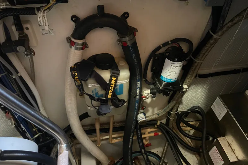 Slide: The Image of Engine room of a 2003 American Tug 34 with various mechanical components and hoses. - 33