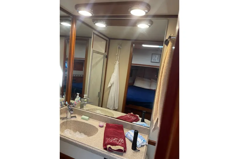 Slide: The Image of Bathroom interior of 2003 American Tug 34, featuring sink, mirror, and shower area. - 16