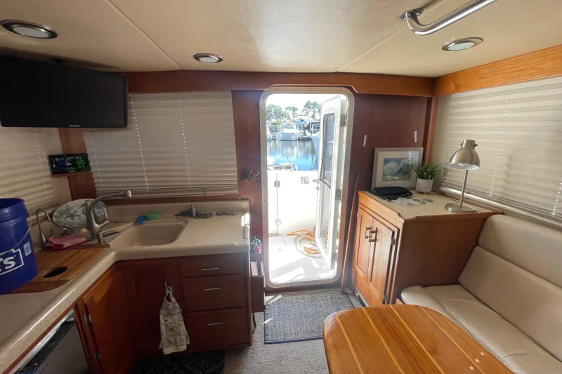 Slide: The Image of Interior of a 2003 American Tug 34, featuring a cozy kitchen and seating area. - 12