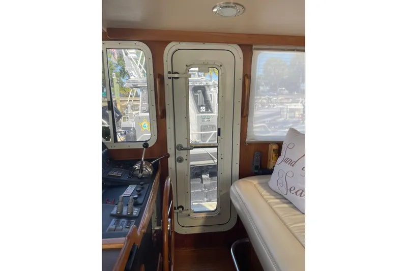 Slide: The Image of Interior view of 2003 American Tug 34, featuring helm controls and seating area. - 21
