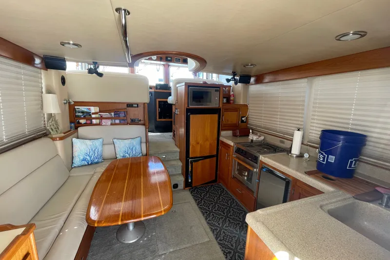 Slide: The Image of Interior of a 2003 American Tug 34, featuring a cozy dining and kitchen area. - 13