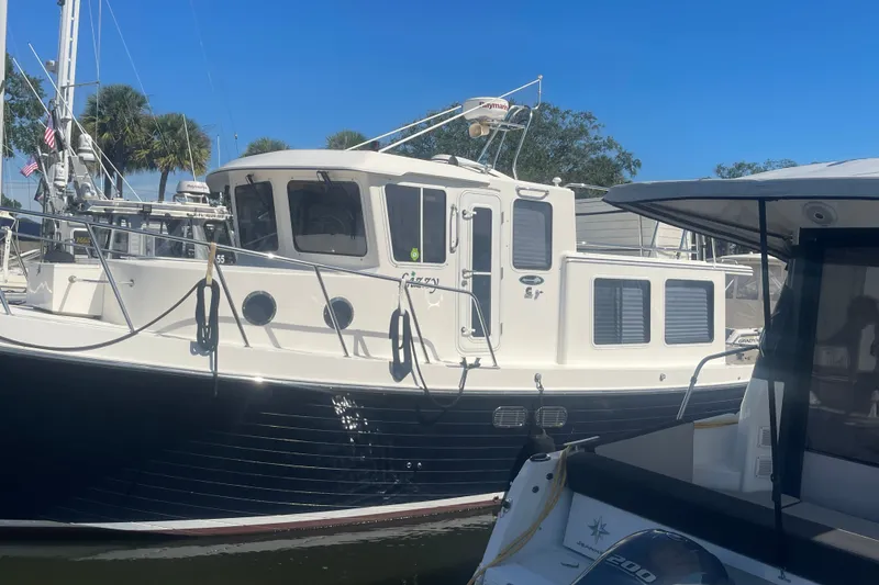 The Image of 2003 American Tug 34 docked, featuring a classic design with a white and navy exterior. - 0