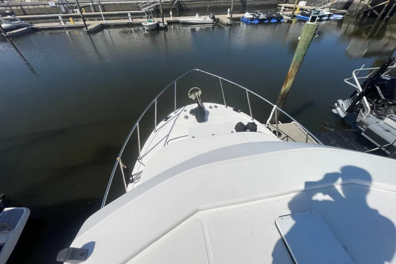 Slide: The Image of 2003 American Tug 34 at dock, viewed from bow, with calm water and marina background. - 5