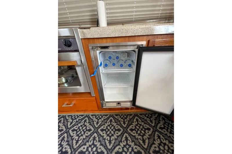 Slide: The Image of Small refrigerator with water bottles inside, located in a 2003 American Tug 34 boat kitchen. - 18