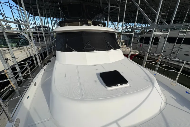 Slide: The Image of 2003 Symbol 50 Pilothouse yacht docked in a marina, showcasing sleek design and spacious deck. - 68
