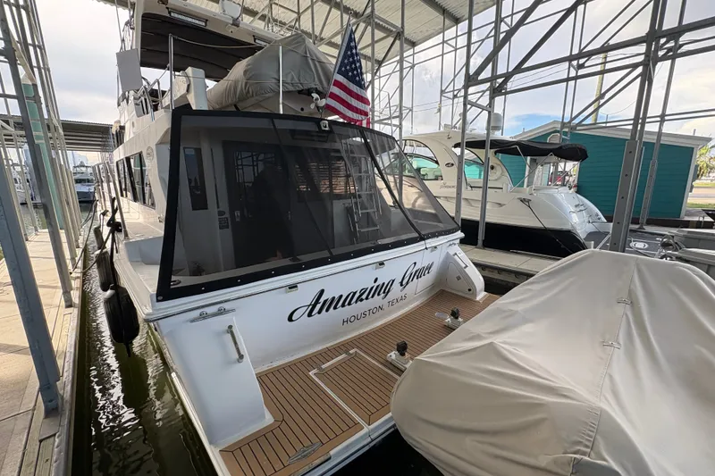 Slide: The Image of Docked 2003 Symbol 50 Pilothouse yacht with American flag, named "Amazing Grace," in Houston marina. - 4