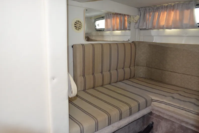 Slide: The Image of Interior cabin of a 2001 Monterey 282 Cruiser with striped seating and curtains. - 24