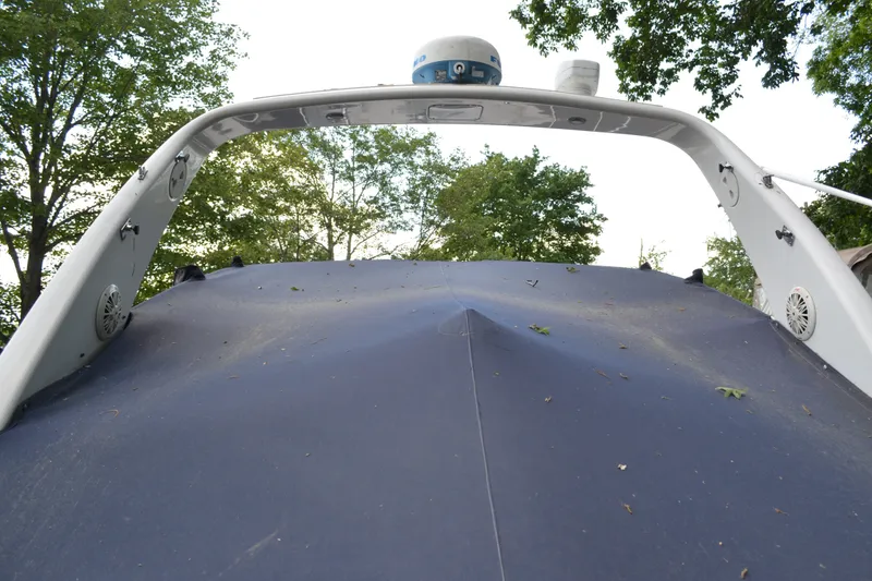 Slide: The Image of 2001 Monterey 282 Cruiser boat with blue cover, surrounded by trees. - 6