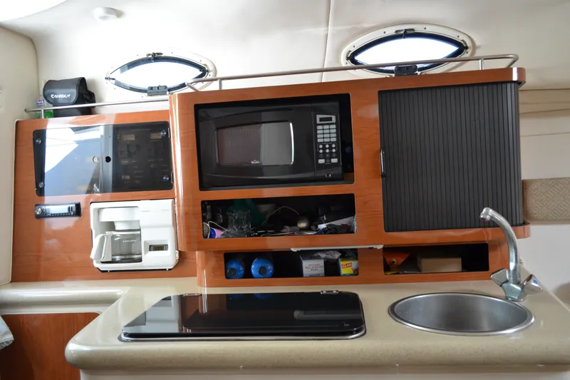 Slide: The Image of 2001 Monterey 282 Cruiser kitchen with microwave, coffee maker, sink, and storage cabinets. - 22
