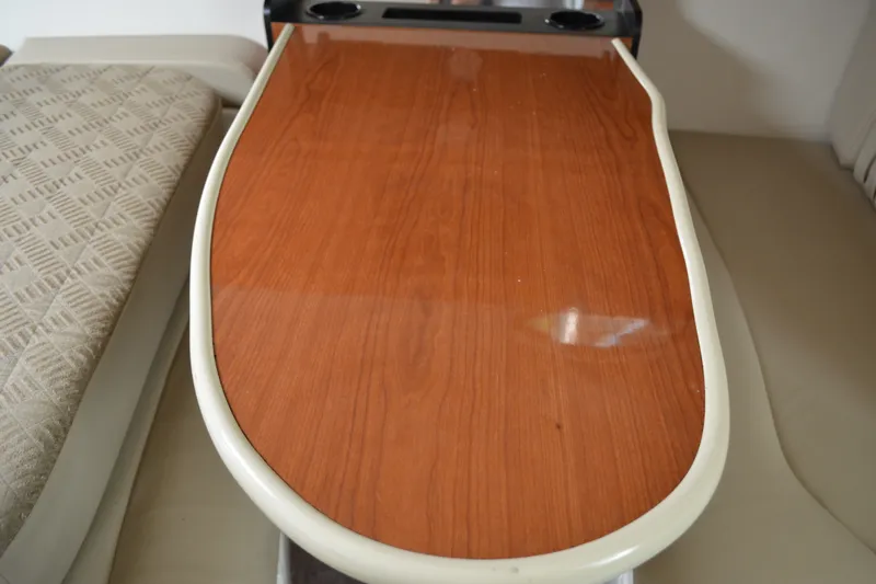 Slide: The Image of Interior of 2001 Monterey 282 Cruiser featuring a polished wooden table and cushioned seating. - 25