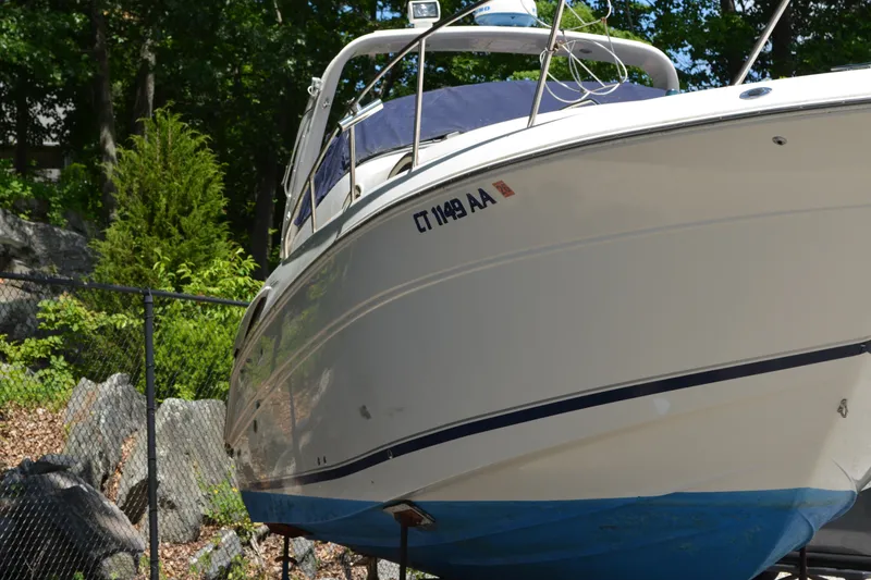 Slide: The Image of 2001 Monterey 282 Cruiser boat on land, surrounded by trees and rocks. - 5