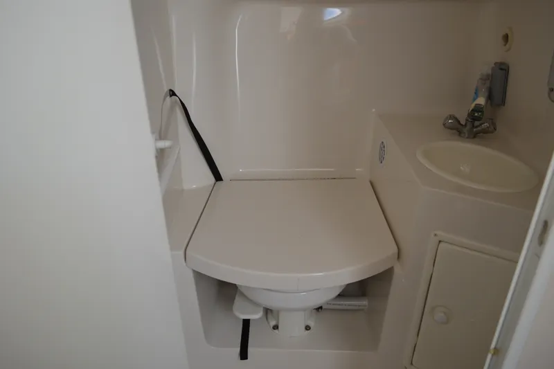 Slide: The Image of Compact bathroom in a 2001 Monterey 282 Cruiser boat, featuring a toilet and sink. - 31