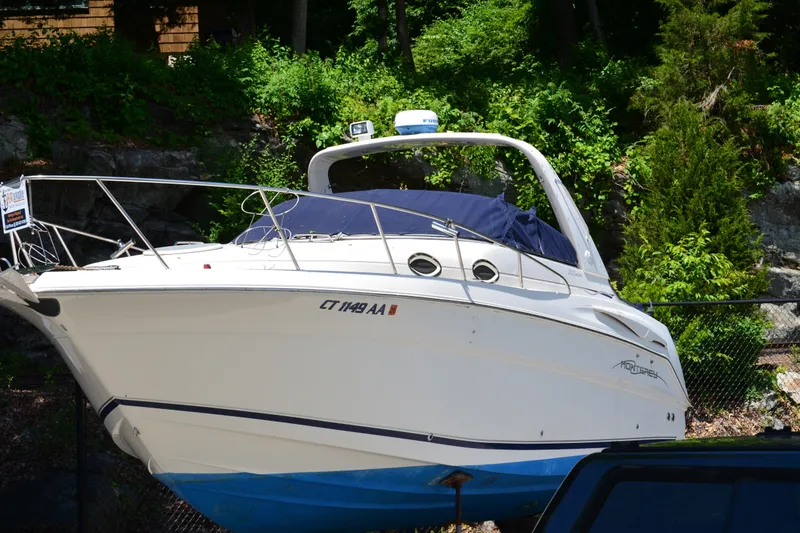 The Image of 2001 Monterey 282 Cruiser boat on land, surrounded by lush greenery. - 0